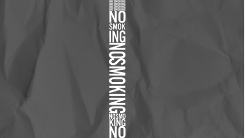 A poster with no smoking text in shape of cigarette with smoke.