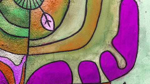 Abstract background image of a fragment of a colored graffiti painting in green and purple tones.