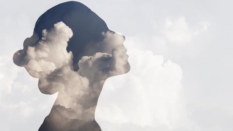 Woman's silhouette overlaid on top of clouds.