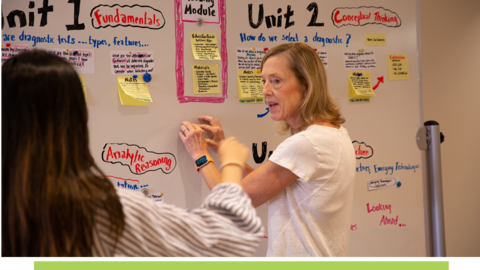 Sue J. Goldie in front of a whiteboard with a student.