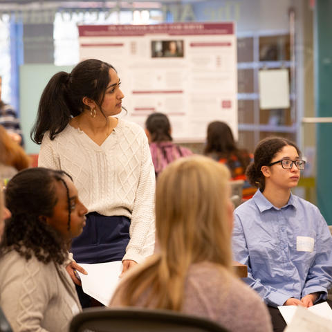 A group of students from GHHP20 watching their classmate present their poster.