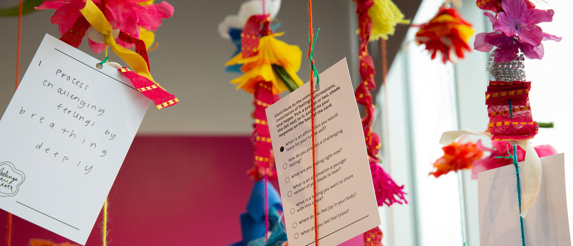 Comment cards hung by colorful string at exhibit.